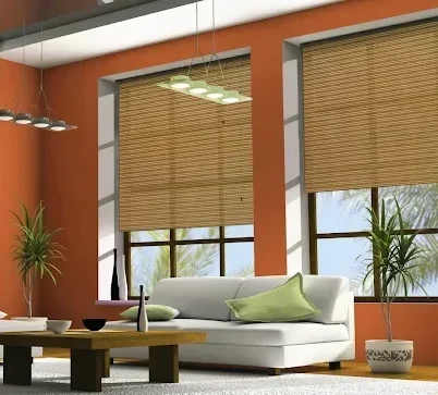 Modern living room with orange walls, bamboo blinds, and white sofa; paint available at Best Paints (at Warwick Interiors), Invermere BC.