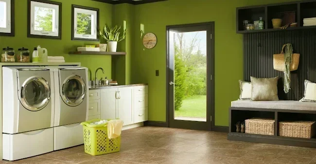 Bright green laundry and mudroom with white cabinets, front-loading washer and dryer, and tile flooring; paint available at Best Paints (at Warwick Interiors), Invermere BC.